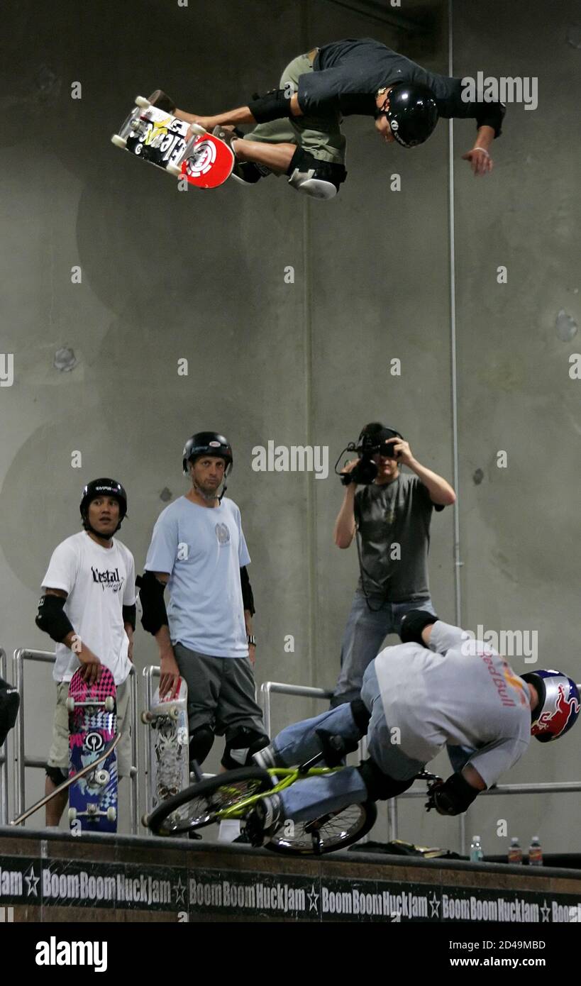Professional skateboarders Tony Hawk (C) and Sergie Ventura (L) watch Brazilian  skater Lincoln Ueda (top) as he leaps over BMX rider Kevin Robinson  (bottom) during rehearsals for the 2005 Boom Boom Huck