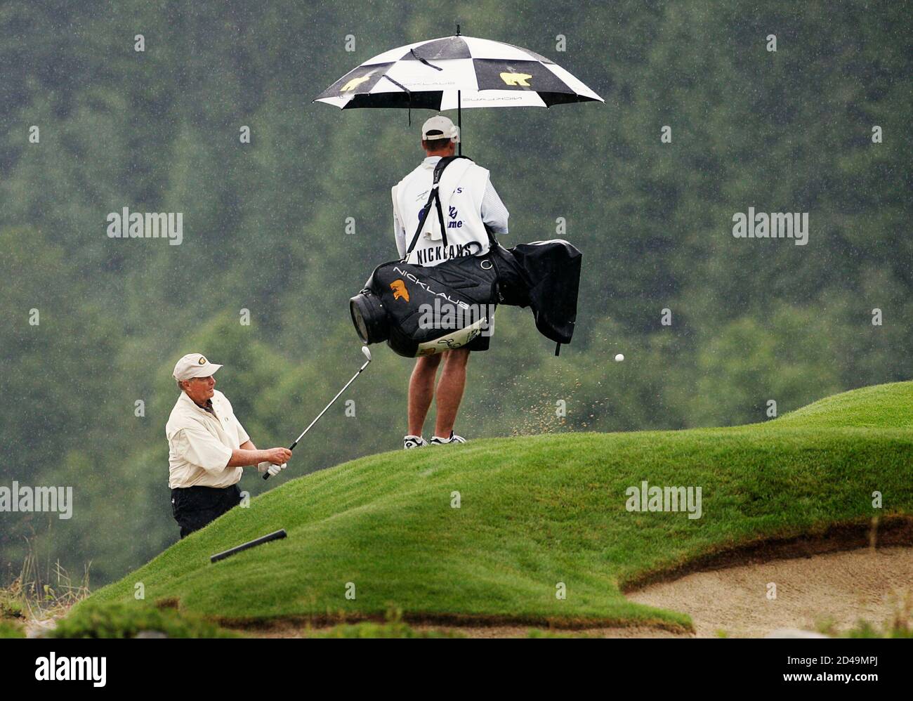 U.S. golfer Jack Nicklaus (L) chips out of the bunker on the 17th green  during the Telus Skins Game in Whistler, British Columbia July 5, 2005.  Nicklaus came in second in the