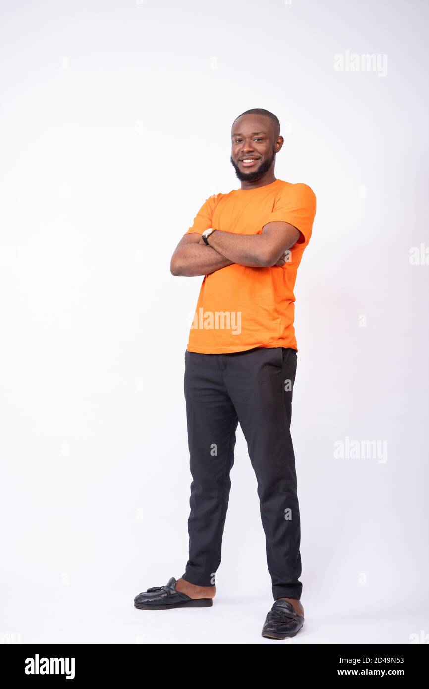 portrait of a young black man standing with arms crossed, and smiling