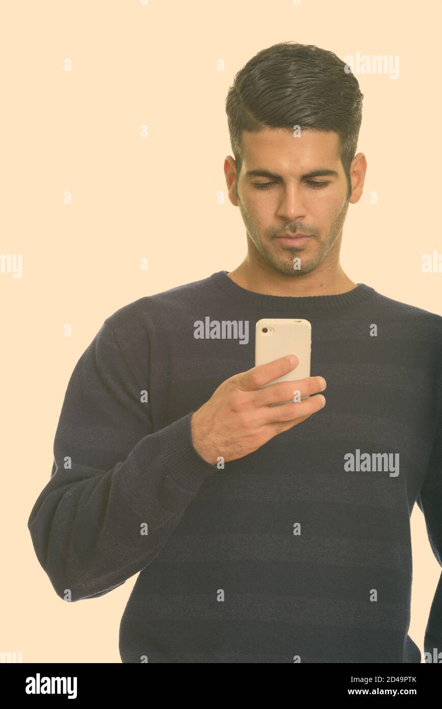 Young handsome Persian man using mobile phone Stock Photo