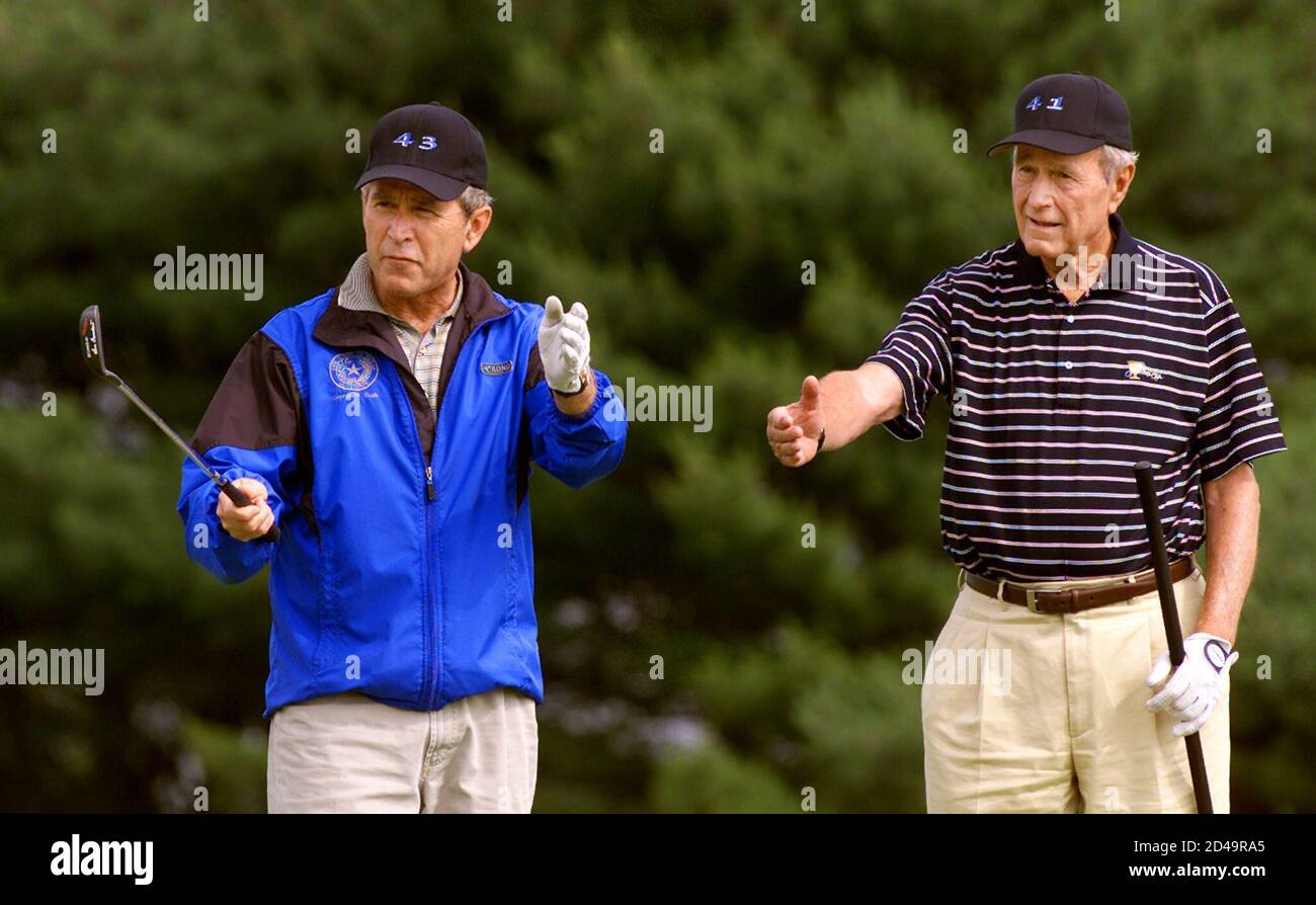 The 43rd U.S. President,  George W. Bush and his father, the 41st President, George Bush (R) gesture on the 18th green as they finish a morning round at the Cape Arundel Golf Club in Maine July 6, 2001. President George W. Bush is celebrating his 55th birthday today. The father-son golf tandem are sporting hats bearing the numbers 41 and 43 reflecting their presidencies. Stock Photo