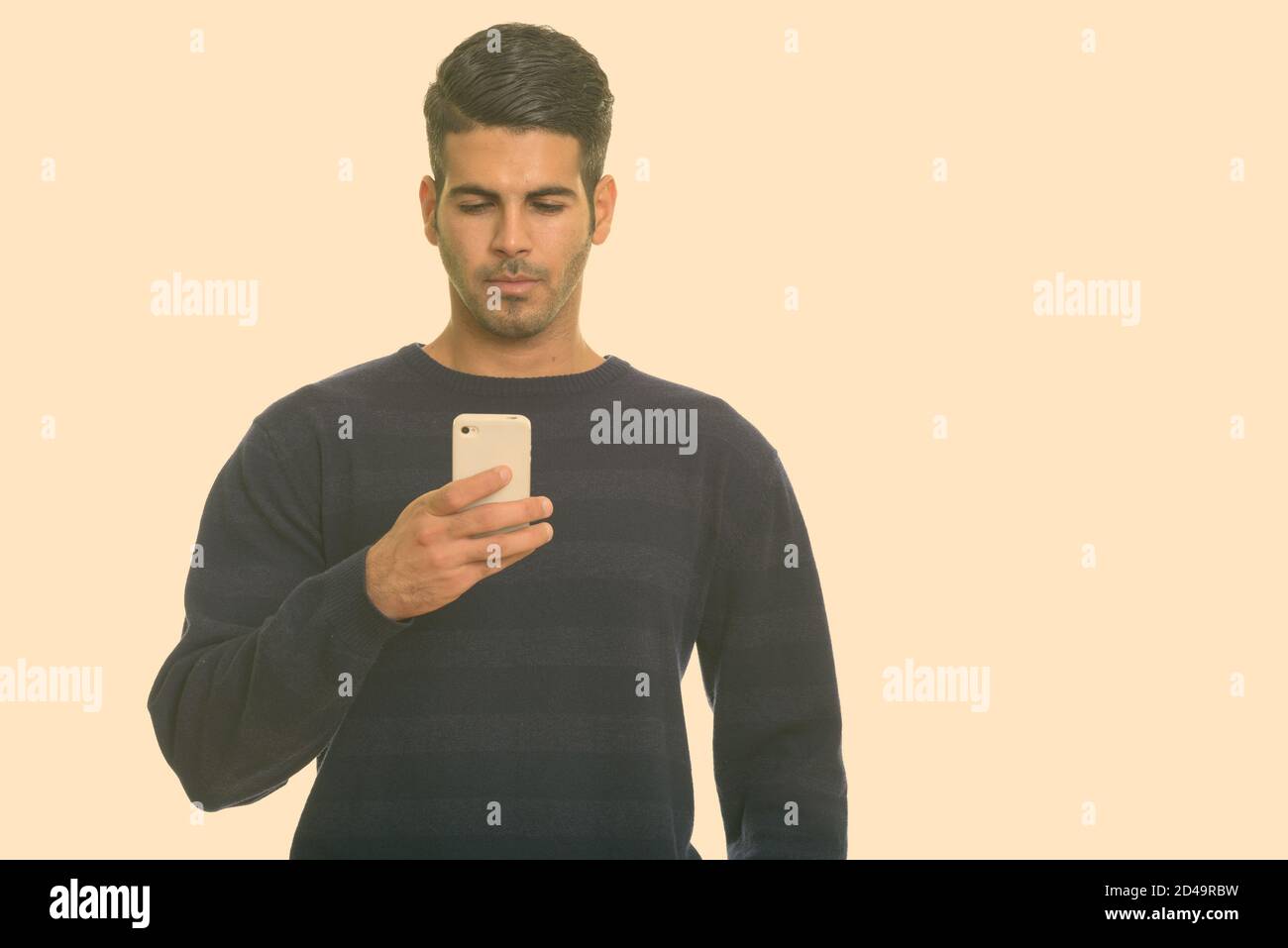 Young handsome Persian man using mobile phone Stock Photo