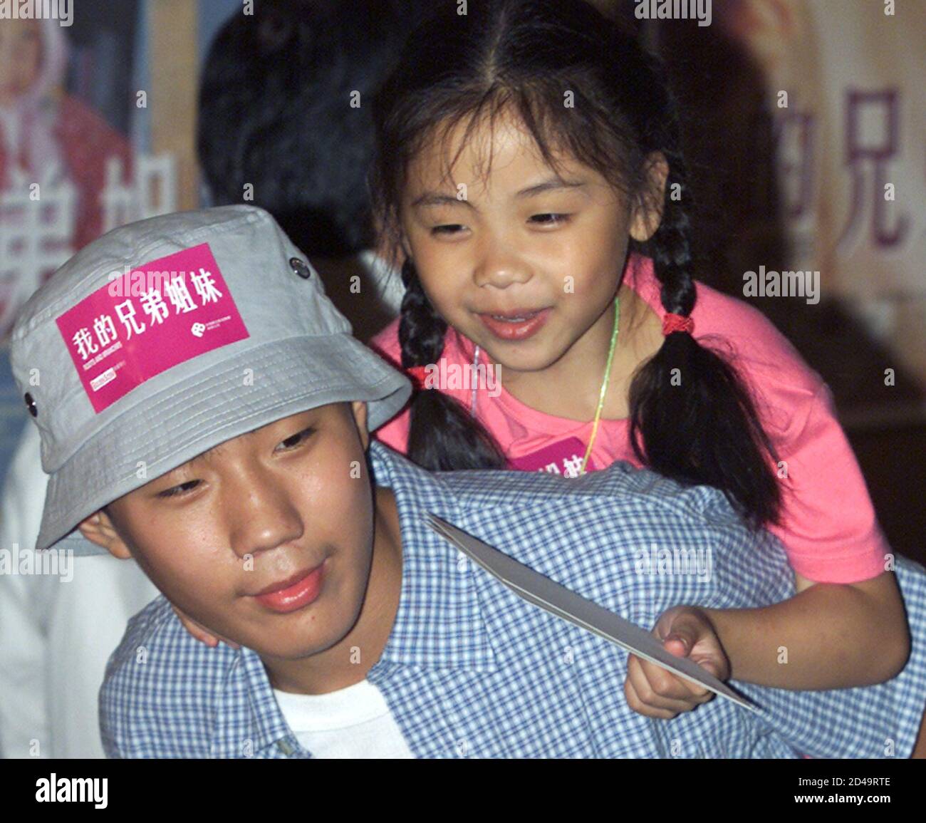 Chinese actor Yang Qingwei, 11 year-old carries actress Na Gege, 5 years-old,  during the premiere of movie "Root And Branches" in Hong Kong September 9,  2001. The movie also starring Chinese actor