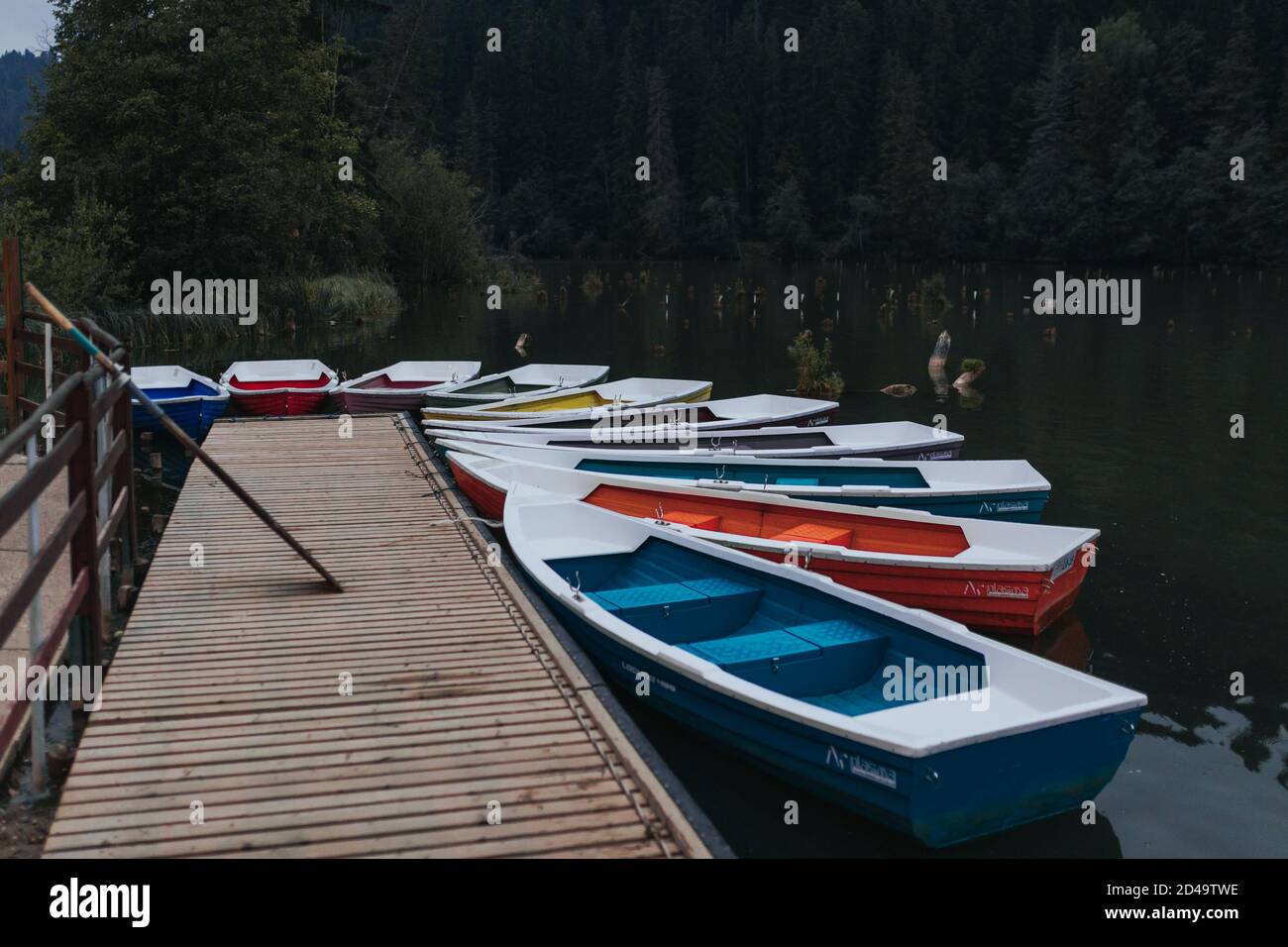 Boats tied to the wooden dock by the lake. Colourful Stock Photo