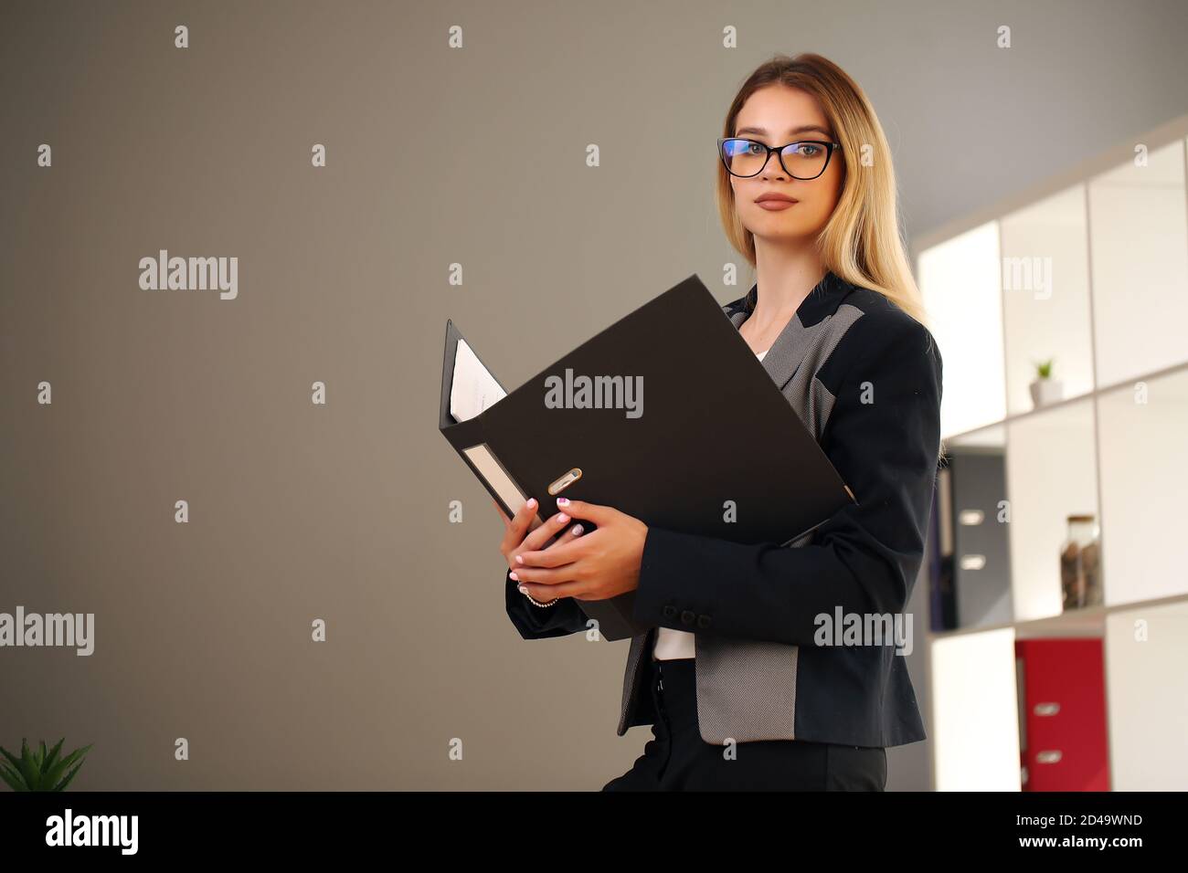 blonde in the office and jacket holding documents Stock Photo