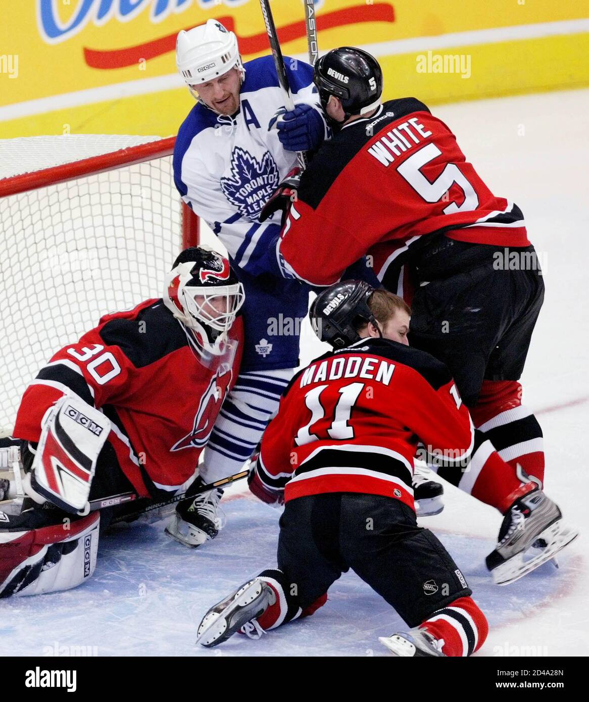 Toronto Maple Leafs Gary Roberts (C) is roughed up in the crease of New Jersey Devils goalie Martin Brodeur (30), by Devils defenseman Colin White (5) and forward John Madden (11) during first period play in Toronto, January 10, 2004. REUTERS/Andrew Wallace  ANW Stock Photo
