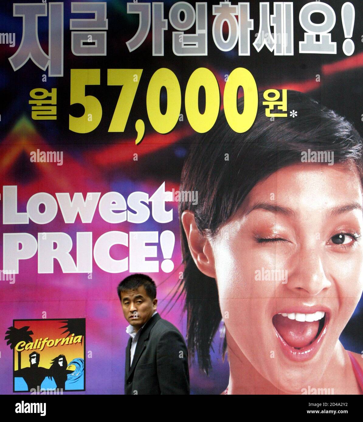 A South Korean man walks past a sign promoting a fitness club in Seoul  March 23, 2004. South Korea's economy grew at its fastest pace in nearly  two years in the final