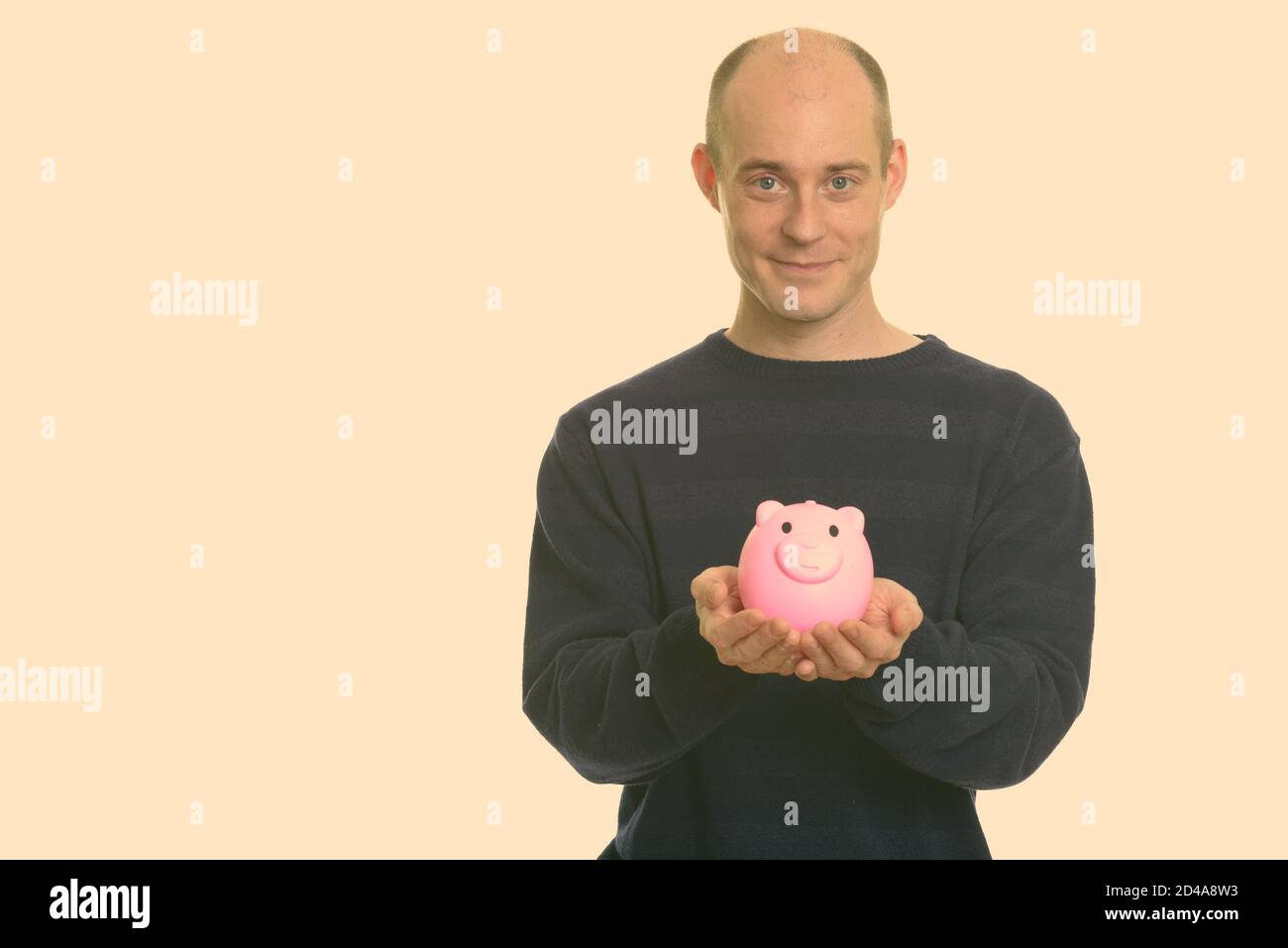 Portrait of handsome bald man giving piggy bank Stock Photo - Alamy