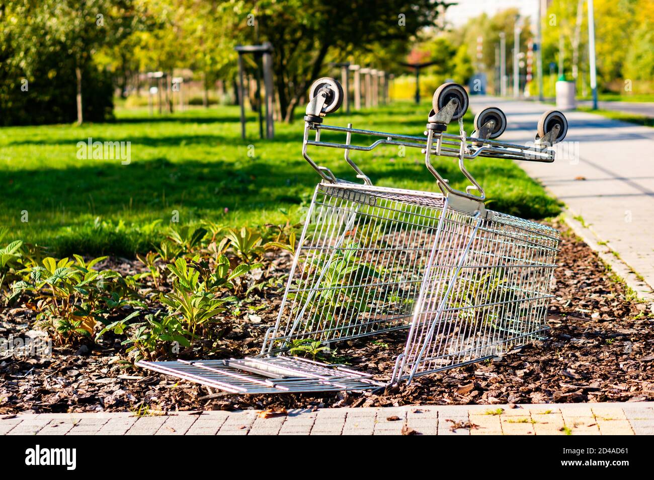 POZNAN, POLAND - Oct 03, 2020: Metal shopping cart laying upside down on the ground at a park Stock Photo