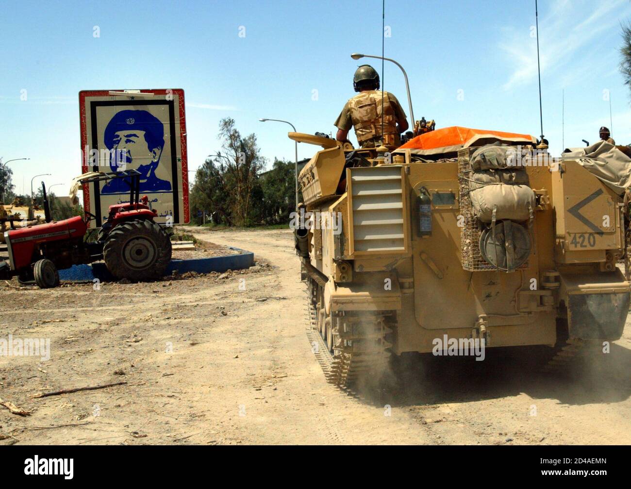 British Light Armored Vehicles (LAV) from the Royal Scots Dragoons Guard move in Basra's industrial estate April, 3, 2003. British forces muscled into the outskirts of Iraq's second city of Basra early on Thursday, capturing an industrial estate where Iraqi militia had spearheaded fierce resistance. Bullet holes pockmarked the walls, burnt-out cars smouldered outside, glass from smashed windows was strewn on the streets and, amid the destruction, a large, colorful Andy Warhol-style picture of Saddam still stands. REUTERS/Yannis Behrakis  YB/WS Stock Photo