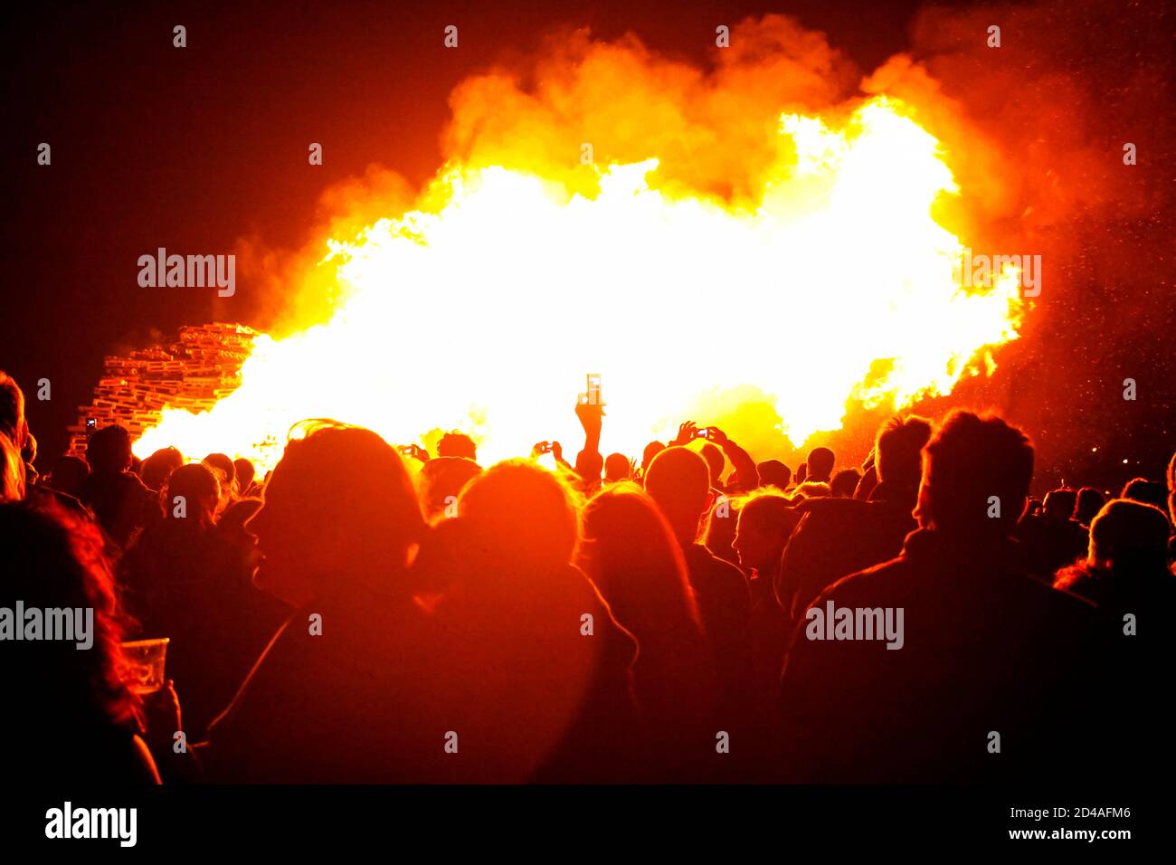 Crowds gather around enormous bonfire at Lewes Bonfire celebration in Sussex, UK marking Guy Fawkes Night and 17 Protestant Martyrs who were burned Stock Photo