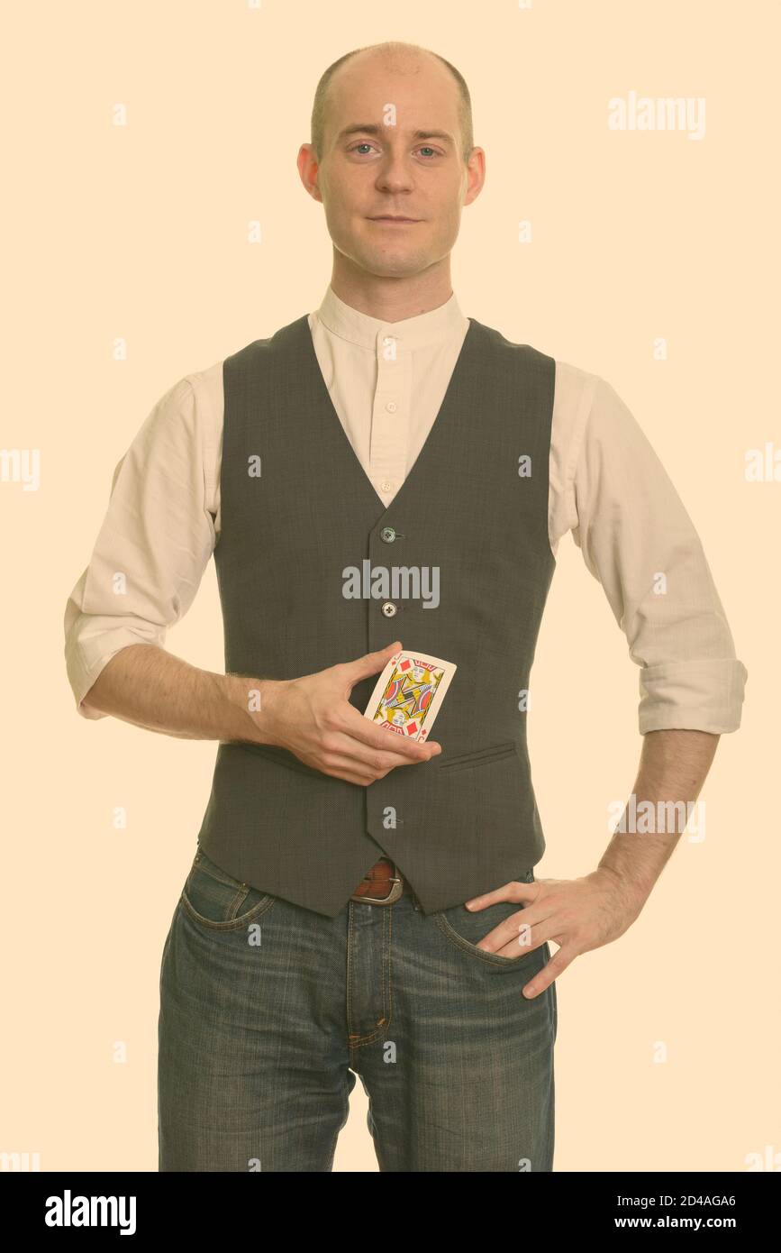 Bald Caucasian magician man holding Jack of Diamonds card with hand on hip Stock Photo