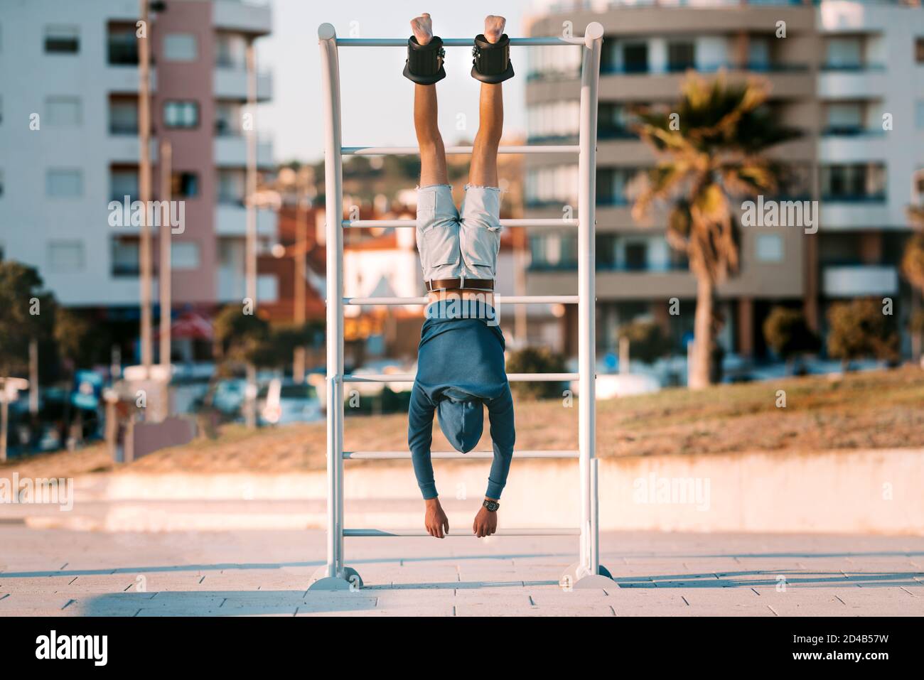 Man hanging upside down on the horizontal bar in anti gravity or inversion boots. Sports equipment. Healthy lifestyle. Stock Photo