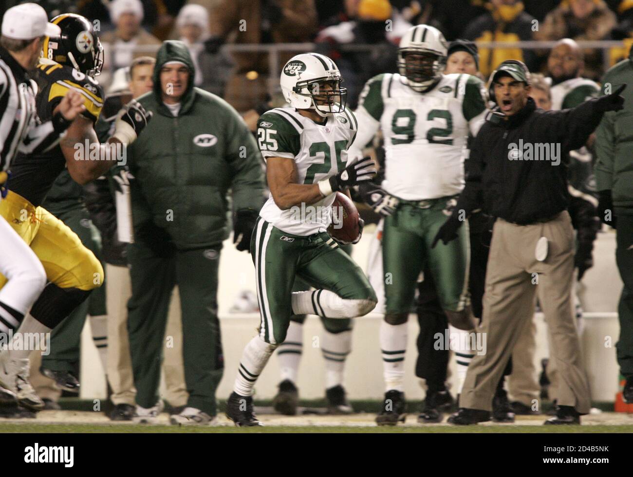 New York Jets' Reggie Tongue (25) runs past Jets head coach Herman Edwards  (R) and Pittsburgh Steelers Keydrick Vincent (L) as he takes an  interception 86 yards for a touchdown during third