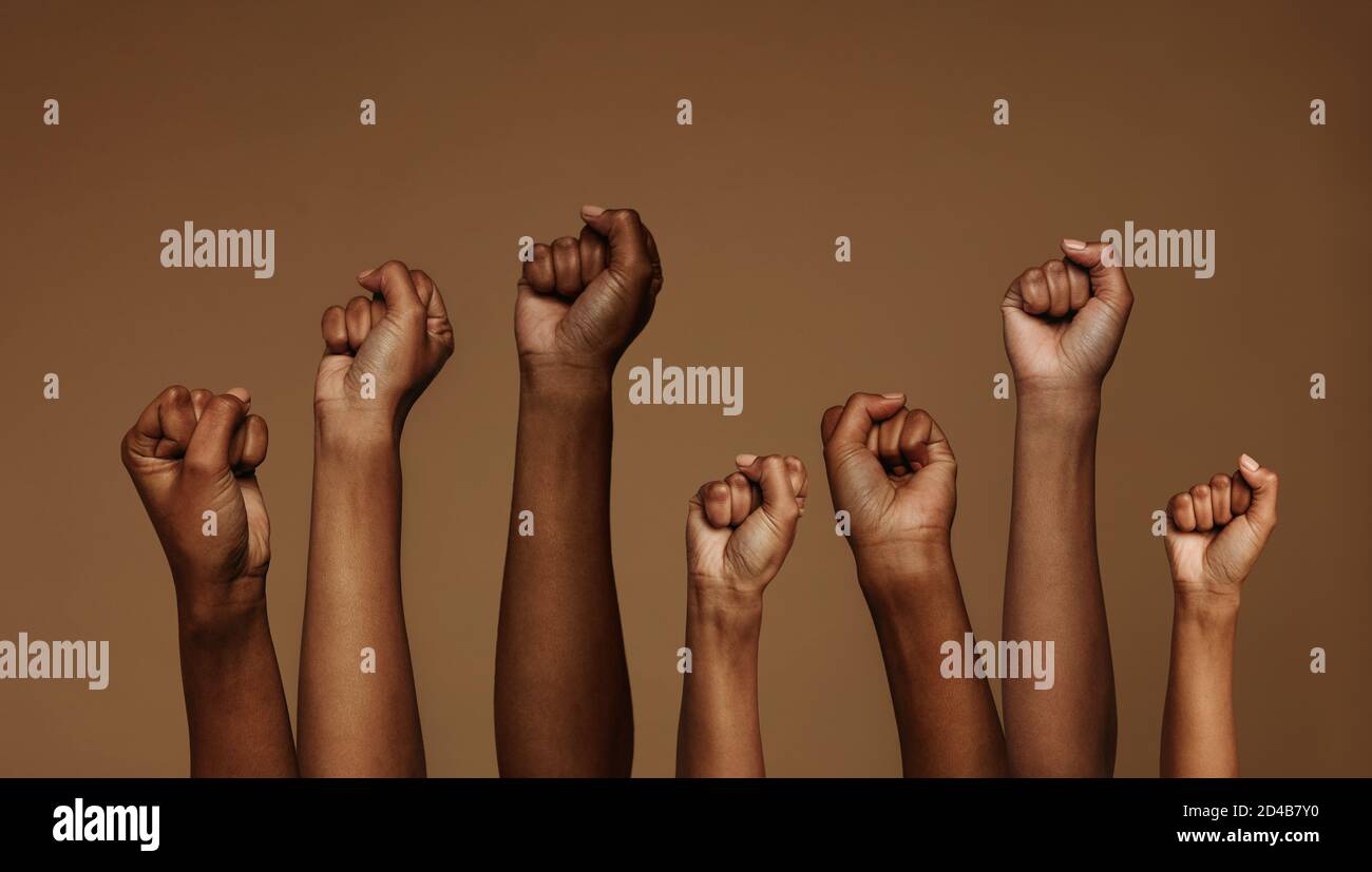 Cropped shot of hands raised with closed fists. Multiple hands raised up with closed fist symbolizing the black lives matter movement. Stock Photo