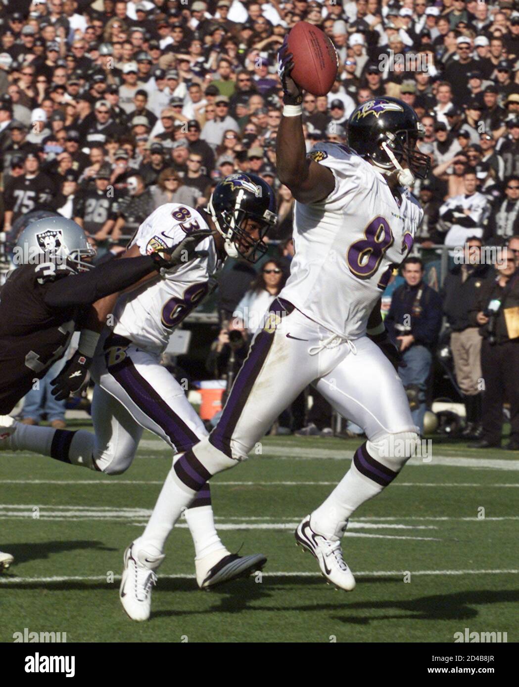 Baltimore Ravens' tight end Shannon Sharpe (R) holds up the ball as he runs  for a 96-yard touchdown in the first half against the Oakland Raiders in  the AFC Championship in Oakland