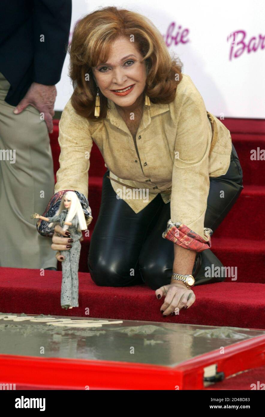 Barbara Handler, daughter of the creator of the Barbie doll, poses as she  holds a Barbie after placing the dolls hand and footprints in cement during  ceremonies November 13, 2002 in Hollywood