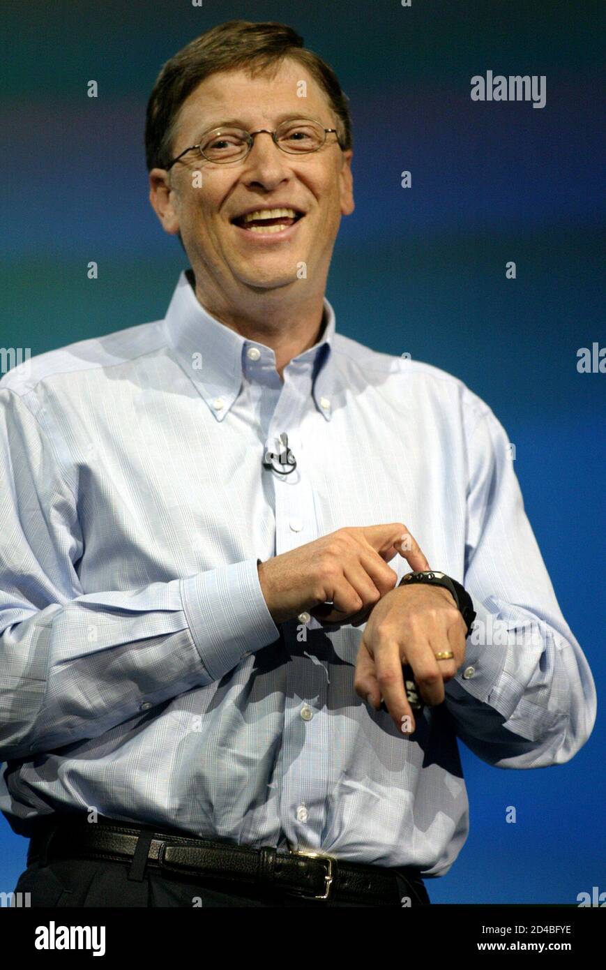 Microsoft Chairman and Chief Software Architect Bill Gates points to his Fossil SPOT watch as he talks about the seamless computing with smart devices during a keynote address for the Comdex computer convention at the Aladdin Theatre for the Performing Arts in Las Vegas, Nevada, November 16, 2003. The watch will be available in early-2004, he said. ??? USE ONLY  (CREDIT : REUTERS/Las Vegas Sun/Steve Marcus) Stock Photo
