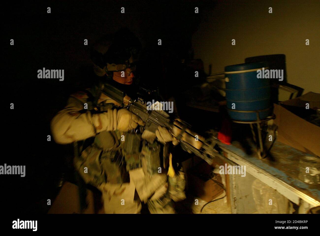 U.S. soldiers from Charlie company of the 3rd Battalion, 21st Infantry searches a house looking for explosives during a raid in Mosul, northern Iraq early January 15, 2005. [A U.S. commander warned al Qaeda ally Abu Musab al-Zarqawi, a driving force behind escalating attacks in the build up to Iraq's election, that American troops were on his trail and would capture or kill him sooner or later.] Stock Photo