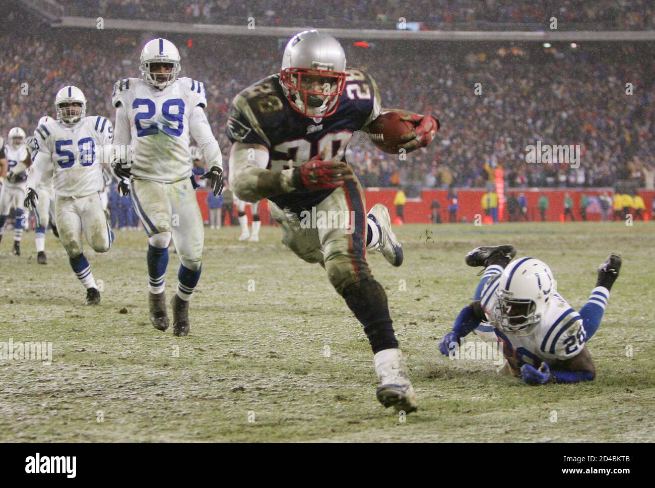 New England Patriots running back Corey Dillon (C) runs for a first down to the one yard line during the fourth quarter of their AFC Divisional playoff game against the Indianapolis Colts in Foxboro, Massachusetts, January 16, 2005. The Patriots scored one play later on a quarterback Tom Brady keeper and went on to win the game 20-3, to advance to the AFC Championship game against the Pittsburgh Steelers next week. Colts defenders Idrees Bashir (28) and Joseph Jefferson (29) and Gary Brackett (58) pursue. REUTERS/Mike Segar  MS Stock Photo