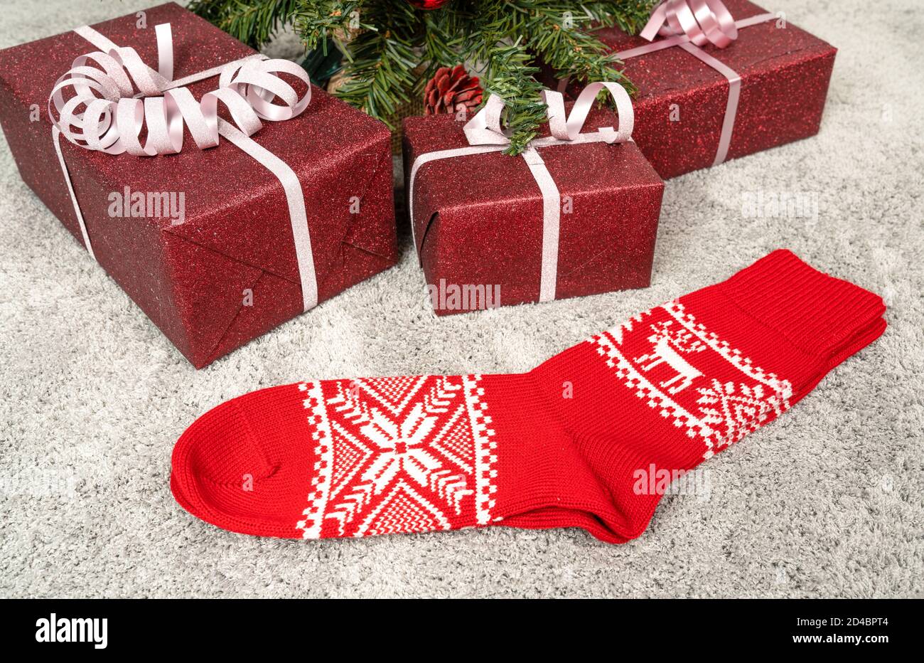 a pair of red Christmas socks under a Christmas tree Stock Photo - Alamy