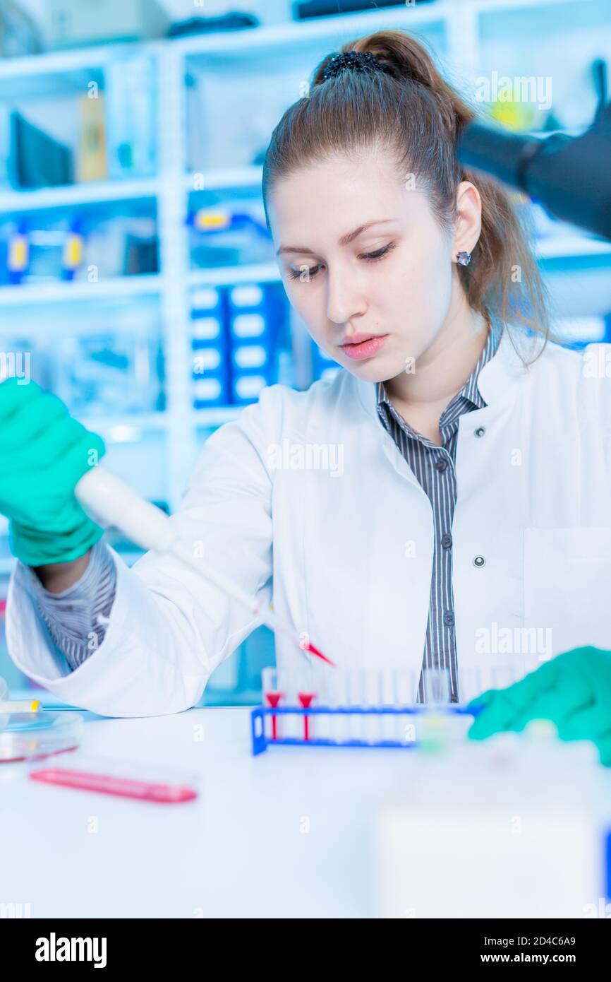 Young female laboratory assistant in laboratory analyzing environmental
