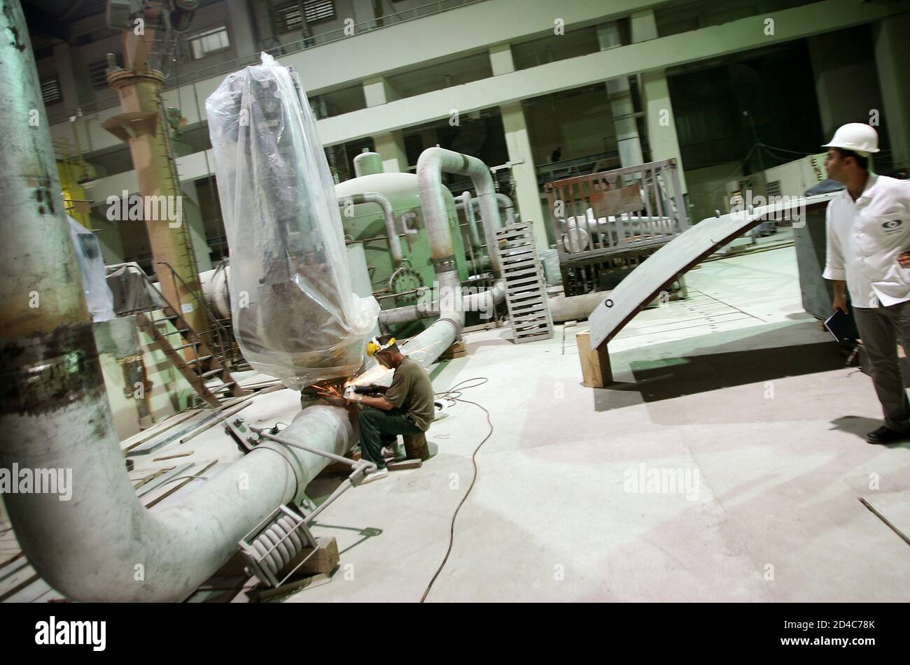 Workers work at the nuclear plant in the southwestern Iranian city of Bushehr June 22, 2005. Russian fuel for Iran's first nuclear power reactor, part of a programme Washington fears may be used to make bombs, will be delivered within months, a senior Iranian atomic official said on Wednesday. Russian welders and other workers working on the electricity turbine area and reactor building, which will be sealed off and operated automatically once fuel is introduced. REUTERS/Damir Sagolj  DS Stock Photo