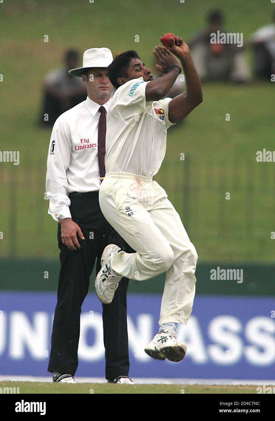 Sri Lankan fast bowler Chaminda Vaas pitches a delivery as Australian umpire Simon Taufel looks on during the third day of the first test cricket match against West Indies in Colombo, Sri Lanka July 15, 2005. REUTERS/Anuruddha Lokuhapuarachchi  AL/KS Stock Photo