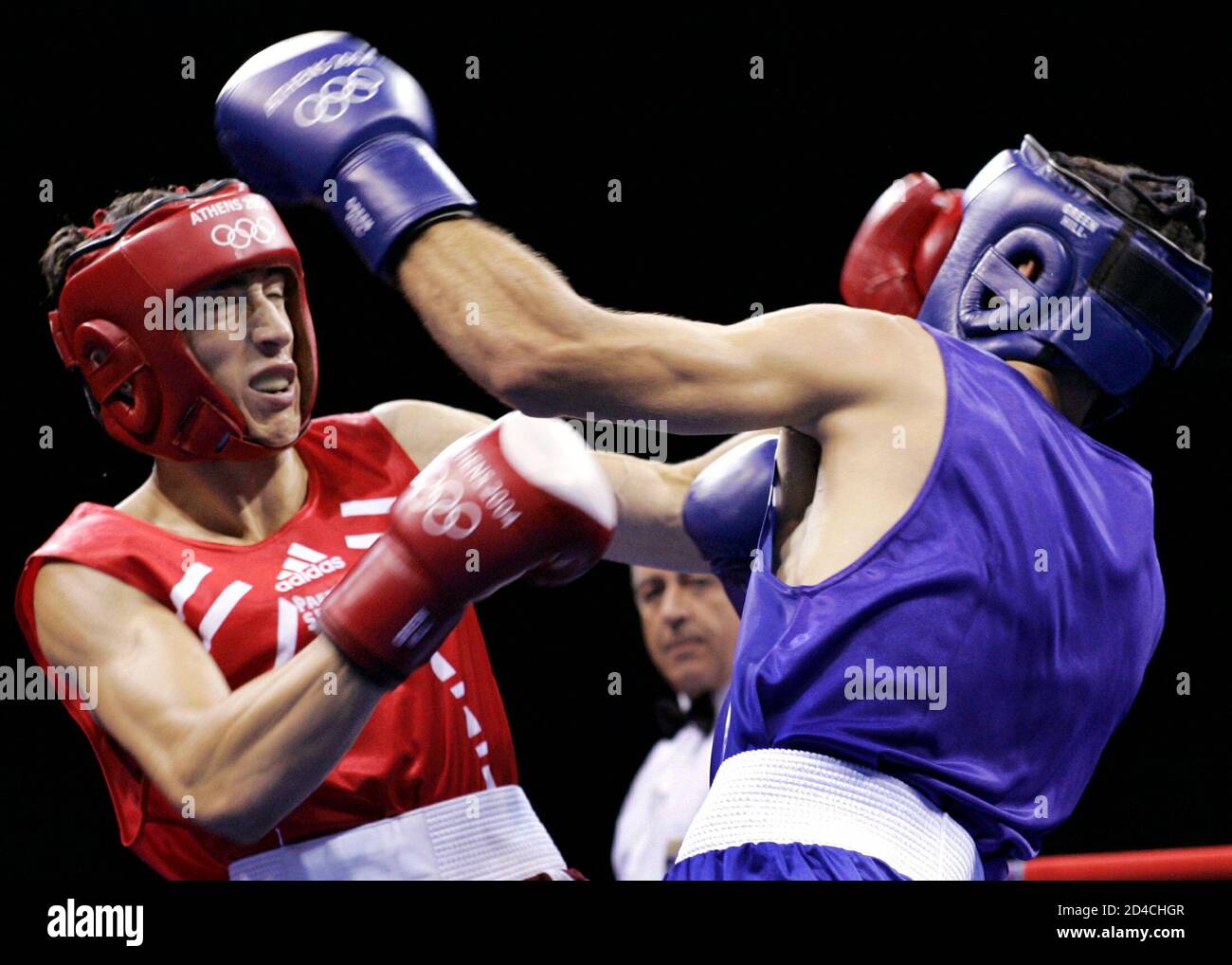 Bulgaria's Boris Georgiev (L) exchanges punches with Nasserredine Fillali of Algeria during their Light Welter Weight (64kg) round of 32 boxing bout at the Athens 2004 Olympic Summer Games August 15, 2004. Georgiev won the fight. Stock Photo