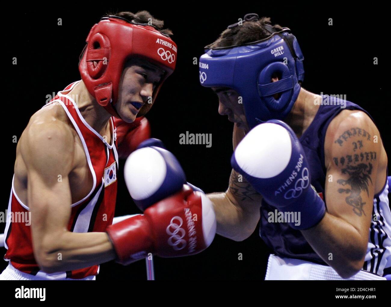 South Korea's Seok Hwan Jo (L) fights Canada's Benoit Gaudet (R) in their featherweight (57kg) round of 16 boxing bout at the Athens 2004 Olympic Summer Games August 20, 2004. Seok Hwan won the bout. Stock Photo