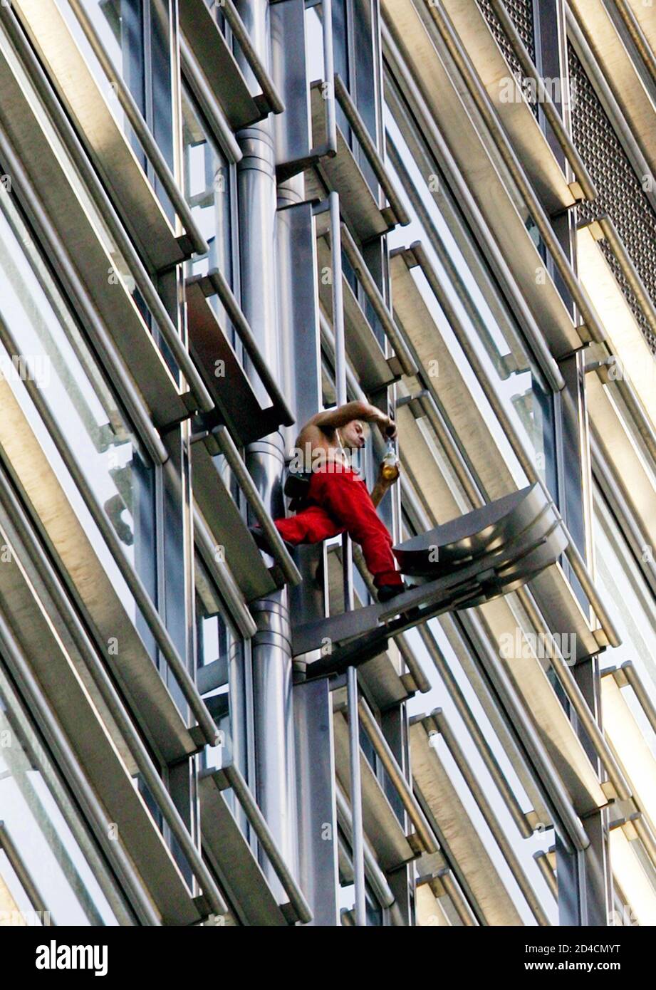 French 'Spiderman' Alain Robert has a drink while climbing up the 62 floor, 283 metre 'Cheung Kong Centre' in central Hong Kong June 11, 2005. Robert, using bare hands and feet, has climbed many world's most renowned structures including [the Empire State Building in New York, the Eiffel Tower in Paris, the Petronas Towers in Kuala Lumpur and Taipei 101 in Taiwan.] Stock Photo