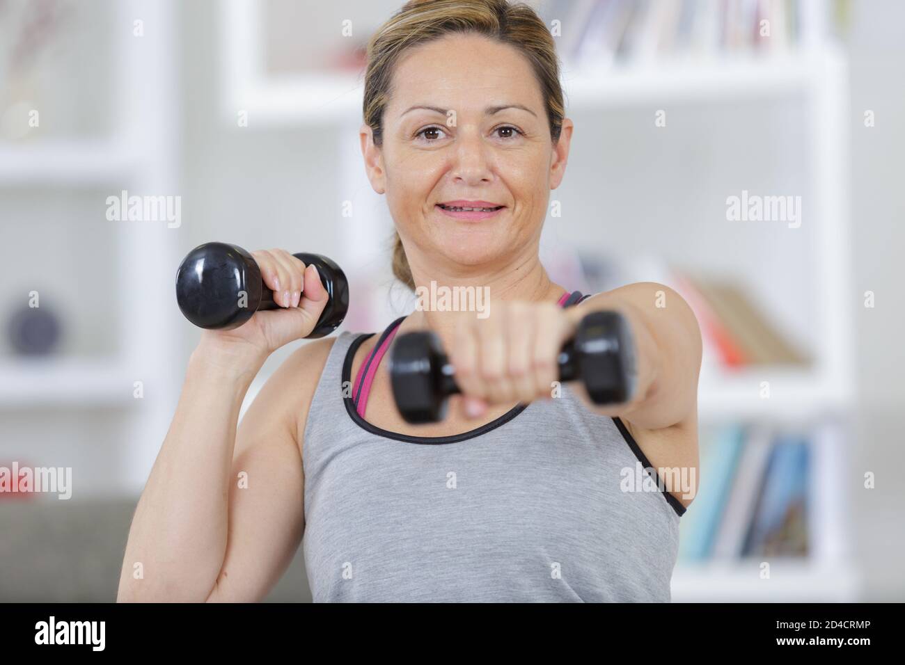 woman working out at home with dumbbell Stock Photo