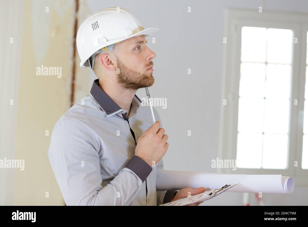 young builder thinking about something Stock Photo