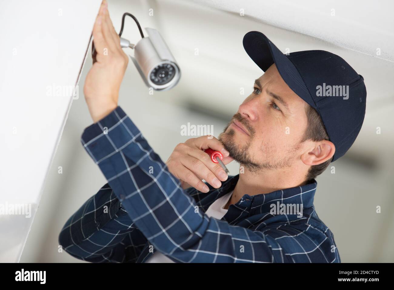 man installs a surveillance camera Stock Photo