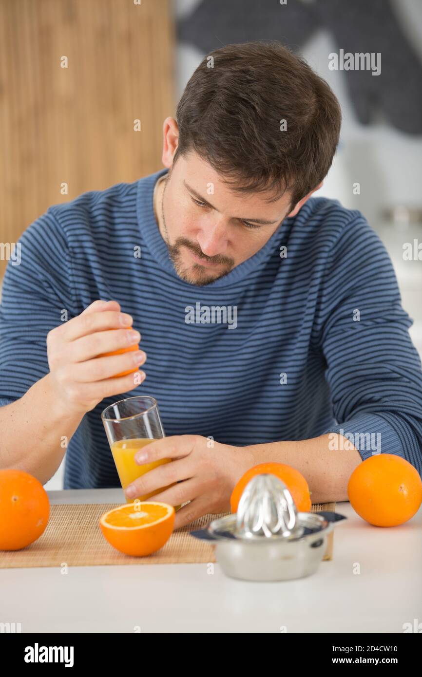 man squeezing oranges for their juice Stock Photo Alamy