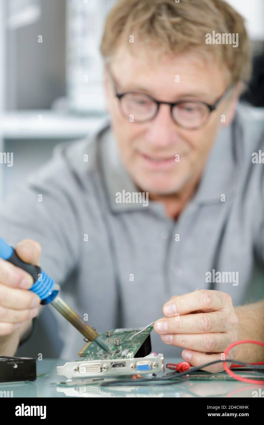 mature technician soldering computer components Stock Photo Alamy