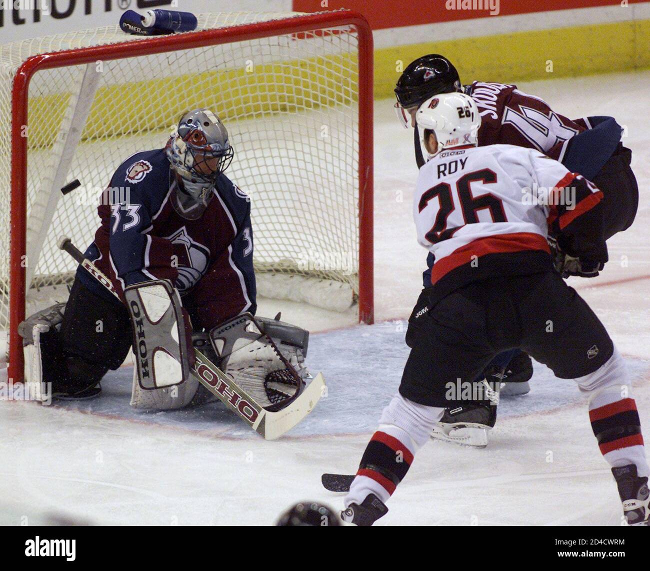 Colorado Avalanche goalie Patrick Roy (L) makes a save off Ottawa Senators'  Andre Roy (26) as Avalanche's Martin Skoula (R) moves in during first  period NHL action in Ottawa, November 8, 2001.