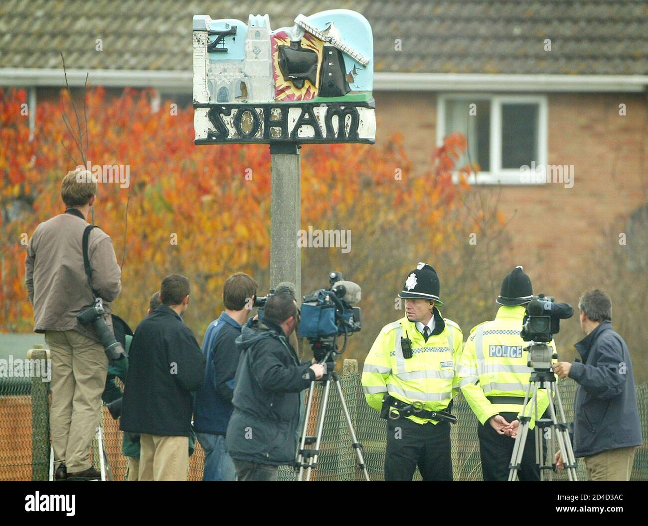 Reporters and cameramen stand with policemen before the coach containing the jurors in the Soham murder trial is escorted into the Cambridgeshire town of Soham November 10, 2003. The jury will be taken to various sites including the house at Number 5 College Close, where Ian Huntley lived and prosecutors say he murdered schoolgirls Holly Wells and Jessica Chapman last August. REUTERS/Peter Macdiarmid  JB Stock Photo