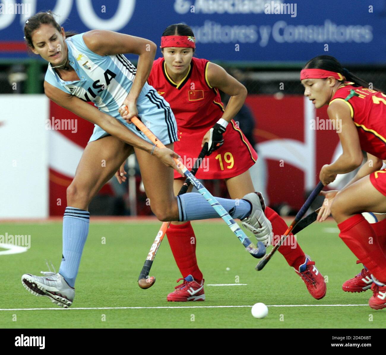 Argentina's Luciana Aymar (L) hits the ball away past China's Zhou Wanfeng  and Quiqi Chen (19) their women's hockey Champions Trophy match, played at  the Jockey Club in the Argentina's city of