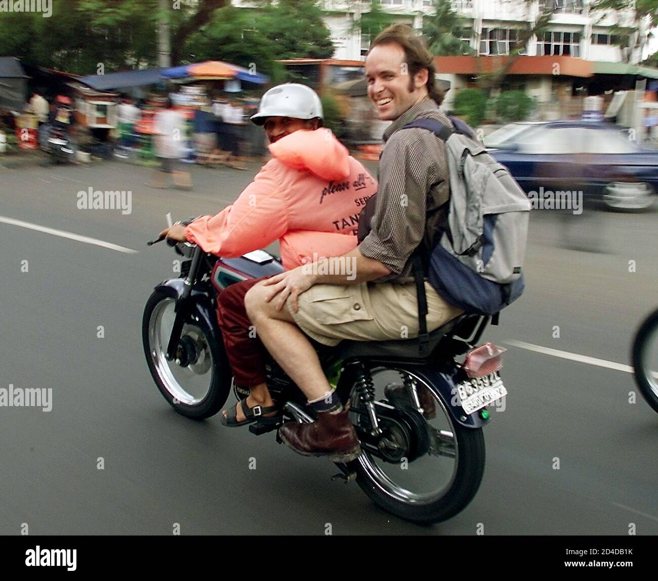 Reuters cameraman Harry Burton from Australia is seen riding on the back of  a motorcycle in Jakarta. Four journalists, including Burton and Reuters  photographer Azizullah Haidari, were killed when gunmen ambushed their