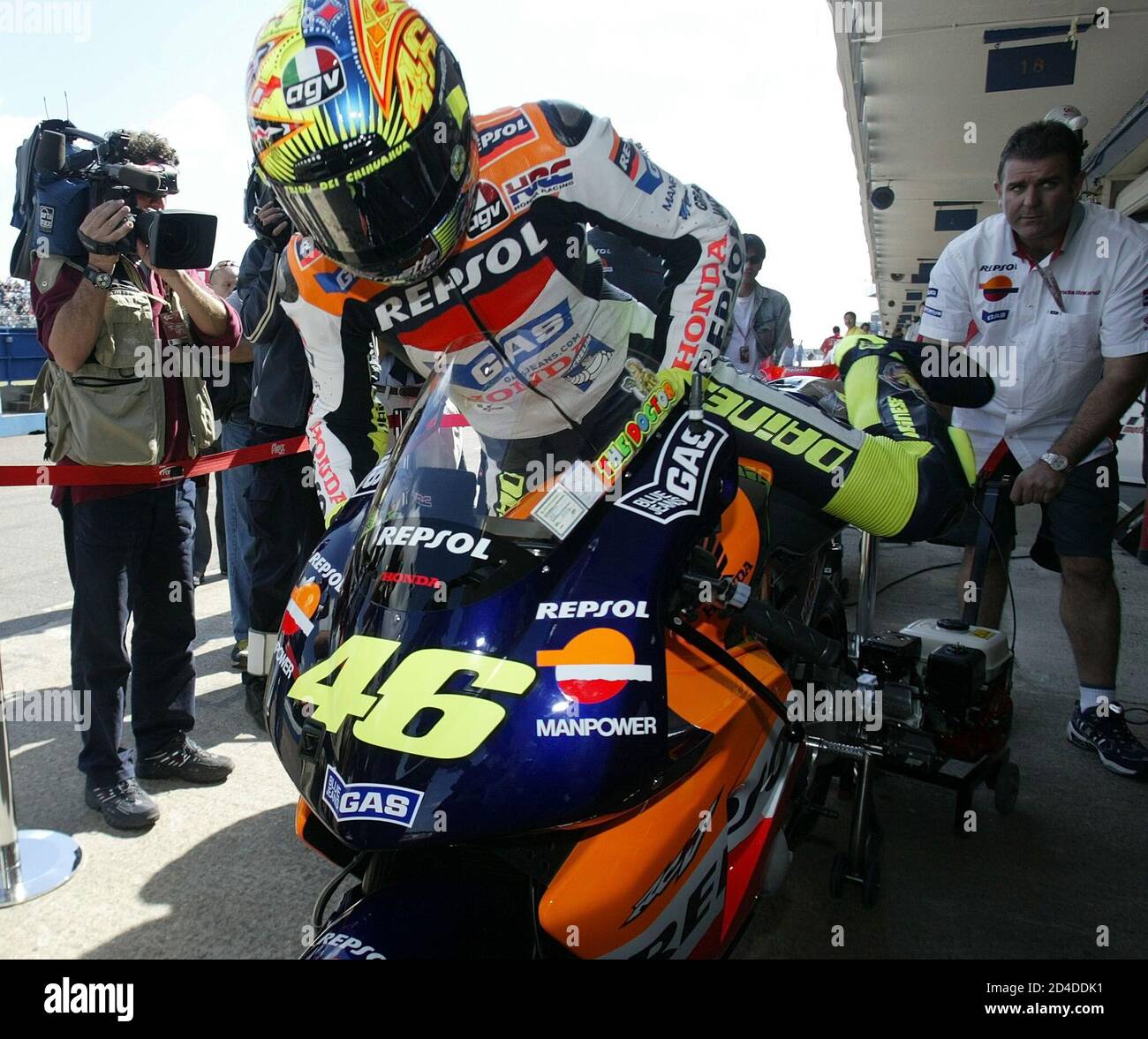Italy's Valentino Rossi climbs onto his motorcycle after medical checks  prior to the second free practice session for the British motorcycling  Grand Prix at Donington Park circuit July 13, 2002. Rossi, riding