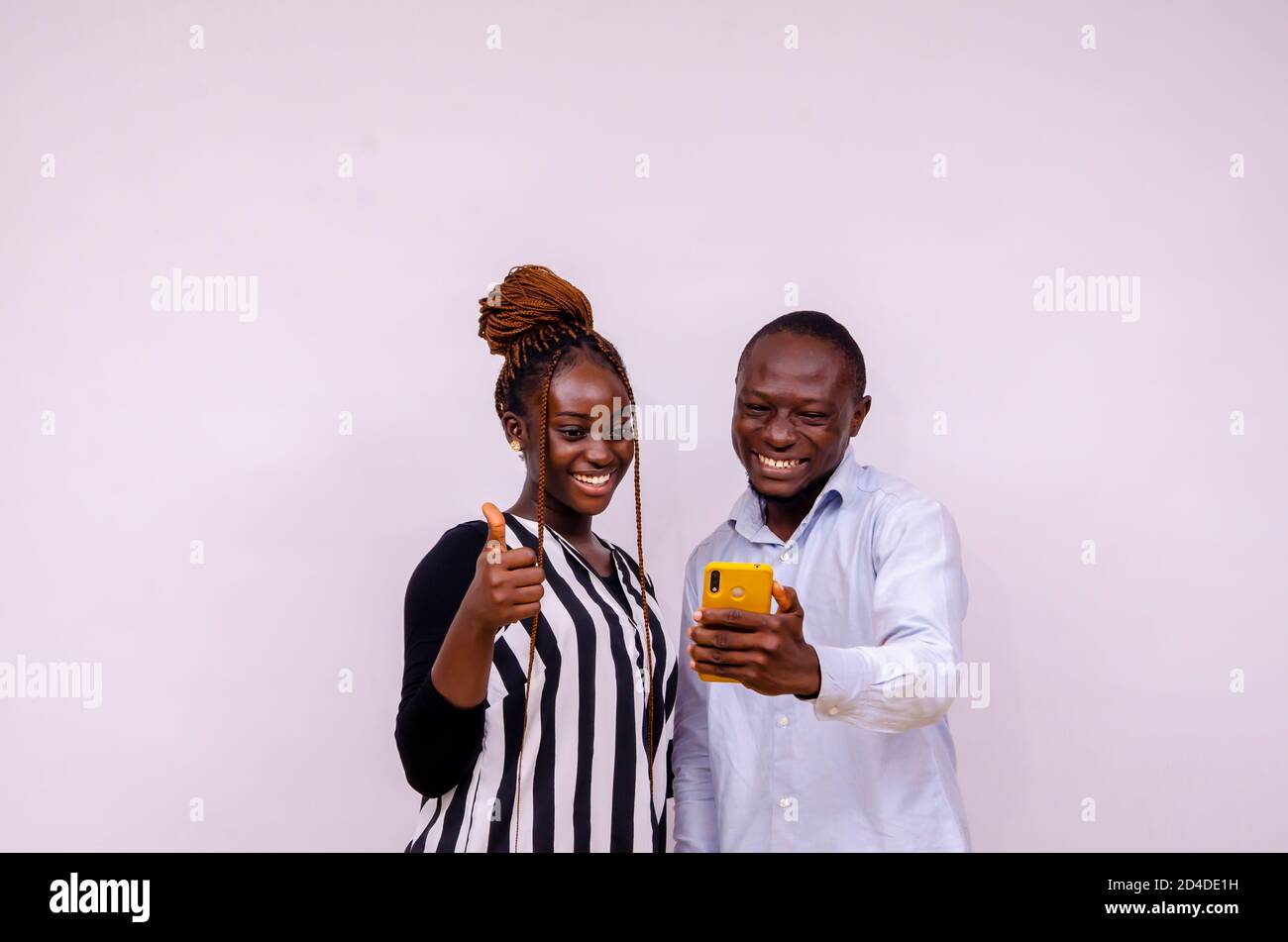 two young male and female hipsters using mobile phone with excitement browsing online news Stock Photo