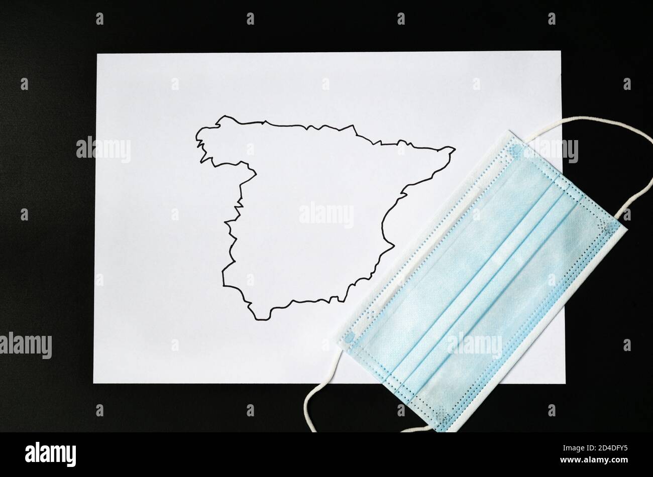 Map of spain drawn on a white sheet with a covid-19 mask coronavirus Stock Photo