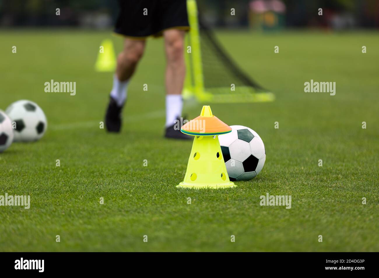 Adult Football Player On Training Unit Running Footballer On Practice Soccer Yellow Cone Training Markers And Soccer Ball In The Foreground Blurre Stock Photo Alamy