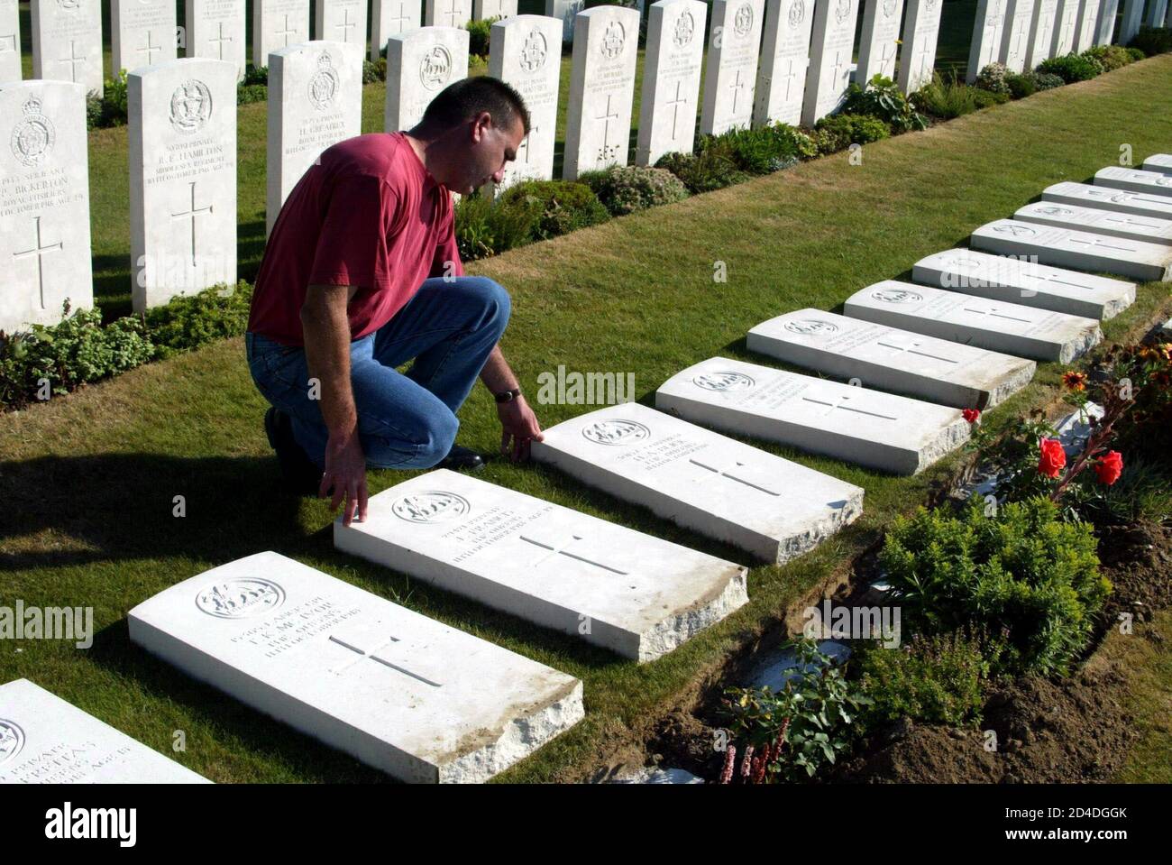 A Commonwealth war graves commission worker repairs one of 45 grave markers, July 29, 2003, after they were desecrated during the night of July 28, 2003 at a World War one cemetery in Saint Aubert, northern France.  Intruders have vandalised dozens of graves at Saint Aubert cemetery in the north of France where the bodies of British Commonwealth troops who fought in World War One lie buried. Stock Photo