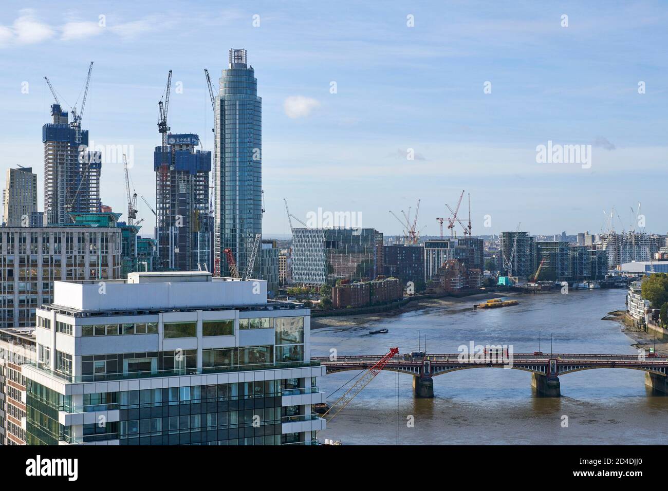 Looking west up the river Thames London, over Vauxhall bridge, towards Battersea power station, with residential development adjacent to the river Stock Photo