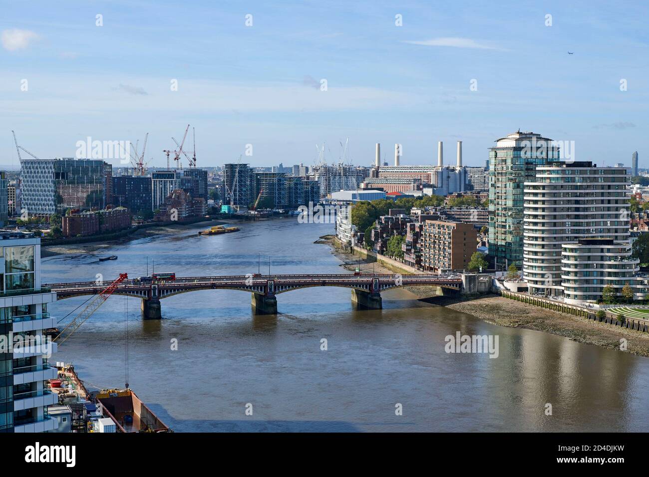 Looking west up the river Thames London, over Vauxhall bridge, towards Battersea power station, with residential development adjacent to the river Stock Photo