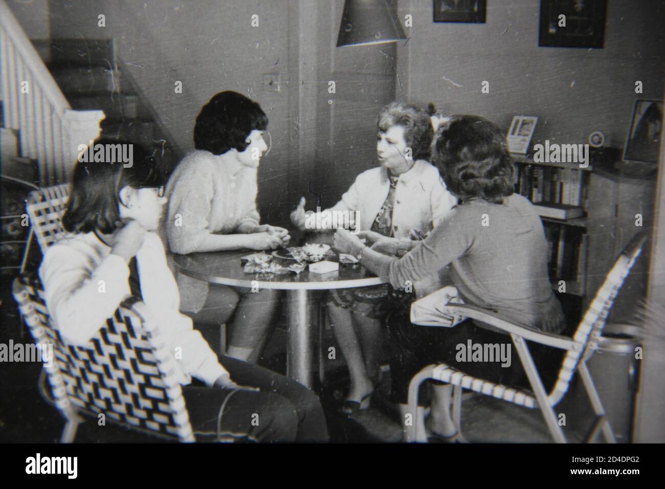 Fine 1970s vintage black and white photography of a casual gathering of girl friends in the kitchen for a cup of coffee. Stock Photo
