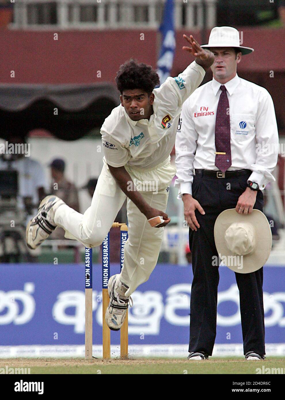 Sri Lankan bowler Malinga pitches a delivery during the cricket test match against West Indies in Colombo.  Sri Lankan bowler Lasith Malinga (L) pitches a delivery as Australian umpire Simon Taufel looks on during the second day of the first cricket test match against West Indies in Colombo July 14, 2005. West Indies were bowled out for 285 on the second morning of the first test against Sri Lanka at the Sinhalese Sports Club on Thursday. REUTERS/Anuruddha Lokuhapuarachchi Stock Photo