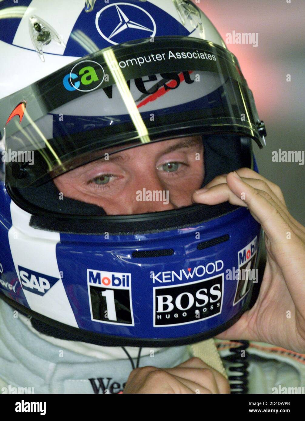 British McLaren driver David Coulthard adjusts his helmet during the  practise session in the Hungaroring on August 18,2001. Ferrari driver  Michael Schumacher, who took the fastest lap in the free practice, needs